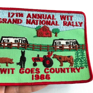 May include: Embroidered patch with a red border and a green background. The patch features a farm scene with a red barn, two RVs, a tractor, and various farm animals. Text includes "17th Annual WIT Grand National Rally" and "WIT GOES COUNTRY 1986".