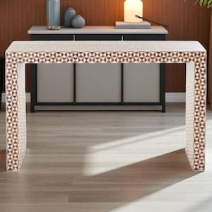 May include: A rectangular console table with a geometric pattern in brown and cream. The table has a clean, modern design with a patterned top and sides. The table is approximately 122 cm long, 41 cm wide, and 76 cm high.