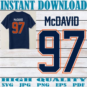 May include: Navy blue t-shirt featuring the name "McDavid" and the number "97" in orange. A digital graphic shows the design, with "INSTANT DOWNLOAD" and "HIGH QUALITY" text at the top and bottom.