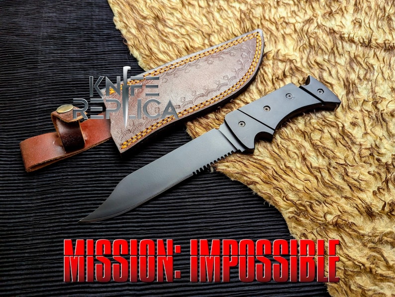 May include: A black knife with a serrated edge and a curved blade, next to a brown leather sheath. The text "MISSION: IMPOSSIBLE" is displayed in red at the bottom. The text "KNIFE REPLICA" is displayed in the upper left corner.
