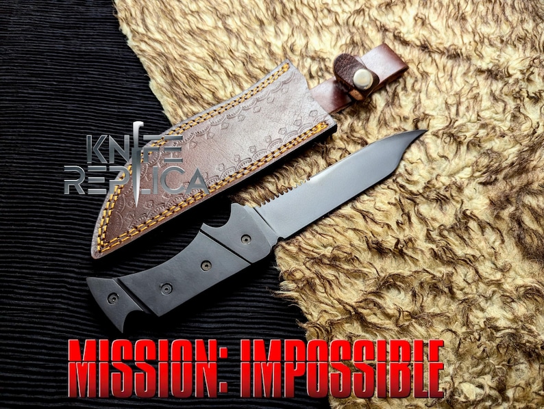 May include: A tactical knife with a silver blade and a black handle, resting on a textured surface. The knife is accompanied by a brown leather sheath with decorative stitching. The text "MISSION: IMPOSSIBLE" is displayed in red.