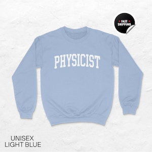 Puede incluir: Sudadera unisex azul claro con la palabra "PHYSICIST" en letras blancas en el pecho. La sudadera tiene mangas largas y cuello redondo. Las palabras "UNISEX LIGHT BLUE" están en la parte inferior de la imagen.