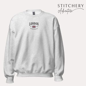 May include: A heather grey sweatshirt with a black graphic on the front that says "LONDON EST. 1968 UNITED KINGDOM" with a small image of the Union Jack flag.