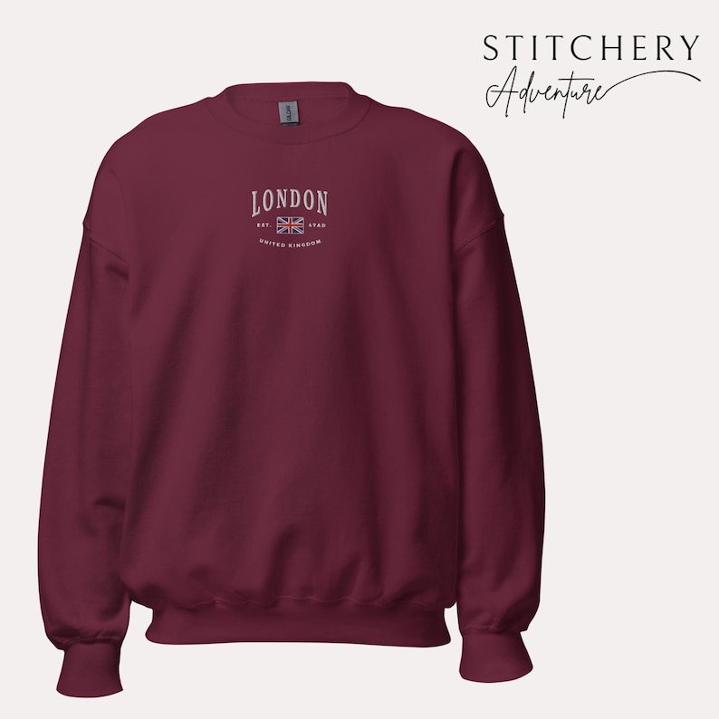 May include: A maroon sweatshirt with a white embroidered design that says "LONDON EST 1948 UNITED KINGDOM" with a small embroidered Union Jack flag.