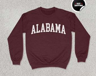 May include: Burgundy sweatshirt with white text that reads "ALABAMA".