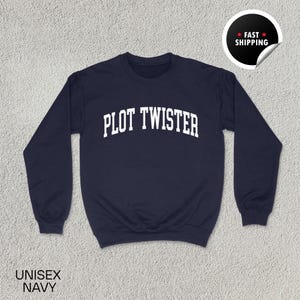 Puede incluir: Sudadera azul marino con el texto "PLOT TWISTER" en letras blancas. La sudadera es unisex y tiene cuello redondo. Una pegatina de "Envío rápido" está en la esquina superior derecha.