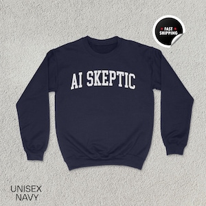 Può includere: Felpa unisex blu navy con la scritta "AI SKEPTIC" a lettere bianche. La felpa ha maniche lunghe e girocollo. Un adesivo "Spedizione veloce" si trova nell'angolo in alto a destra. Le parole "UNISEX NAVY" sono in basso.