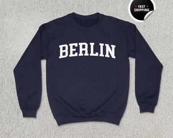 May include: A navy blue sweatshirt with the word "BERLIN" printed in white on the front.