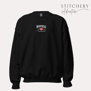 May include: Black sweatshirt with the word "MONTREAL" in white, above a Canadian flag graphic. The text "EST 1642" and a French phrase are below the flag. The brand name "STITCHERY Adventure" is in the upper right corner.