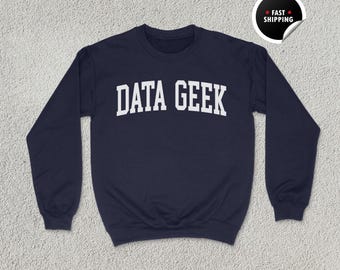 May include: Navy blue unisex sweatshirt with the text "DATA GEEK" in white block letters. The sweatshirt has a crew neck and long sleeves. The words "UNISEX NAVY" are printed at the bottom left.