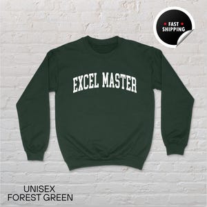 May include: A dark green unisex sweatshirt featuring the white text "EXCEL MASTER". The long-sleeved top has a crew neck. The words "UNISEX FOREST GREEN" are printed at the bottom of the image.