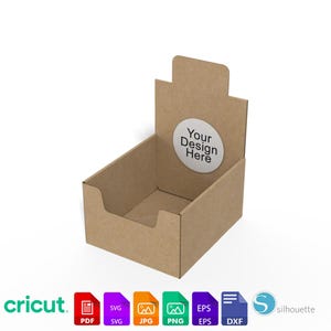 以下が含まれることがあります： 長方形のベースと背面パネルを備えた茶色の段ボール製ディスプレイボックス。 「Your Design Here」というテキストが入った白いステッカーが背面パネルに貼られています。 Cricutのロゴとファイルタイプのアイコンが下にあります。
