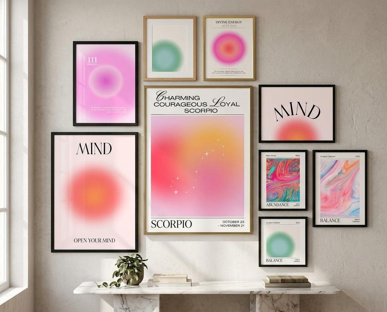 May include: A gallery wall arrangement featuring nine framed posters with aura gradient designs, including text such as Charming Courageous Loyal Scorpio, Mind, Divine Energy, Abundance, and Balance, displayed in black and gold frames on a wall.