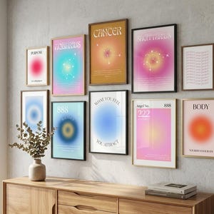 May include: A gallery wall arrangement of ten framed posters featuring gradient aura designs, zodiac constellations, and motivational text including Purpose, Aquarius, Cancer, Sagittarius, 888 Balance, What You Feel You Attract, Angel No. 222, and Body.
