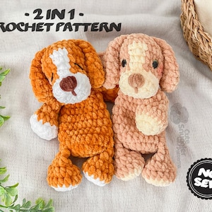 May include: Two crocheted dog plushies. One is orange and white, the other is pink and cream. The text "-2 IN 1- CROCHET PATTERN" is at the top. The plushies are on a white surface with greenery and a woven basket in the background. The words "NO SEW" are in a black circle.