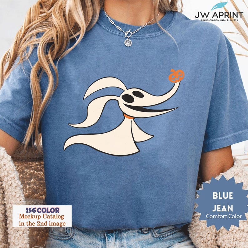 Puede incluir: Camiseta azul vaquero de color c&oacute;modo con un perro fantasma de dibujos animados con una nariz de calabaza. La camiseta tiene el texto "JW APRINT" y "BLUE JEAN Comfort Color". La imagen tambi&eacute;n incluye el texto "156 COLOR Mockup Catalog in the 2nd image".