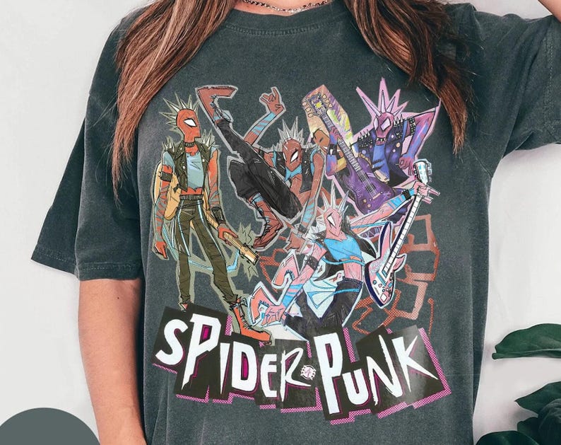 May include: Dark gray t-shirt featuring a colorful graphic of Spider-Man characters playing musical instruments. The design includes the text "SPIDER-PUNK" in a stylized font, with a punk rock aesthetic.