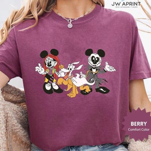 Puede incluir: Camiseta de color bayas con un gr&aacute;fico de personajes de dibujos animados. El dise&ntilde;o incluye una ratona con pelo rojo, un perro con capa y un personaje con traje. La camiseta tiene el texto "JW APRINT" y "BERRY Comfort Color".