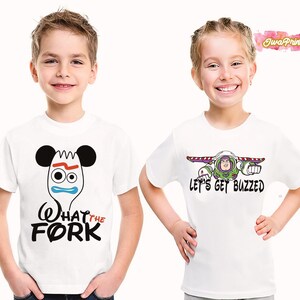 May include: Two white t-shirts with cartoon graphics. One shirt features a fork character with the text "What the Fork" in black. The other shirt displays Buzz Lightyear with the text "Let's Get Buzzed" in black.