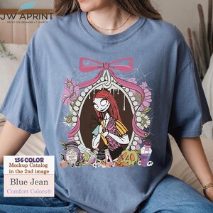 May include: Blue jean Comfort Colors&reg; t-shirt featuring a graphic of Sally from The Nightmare Before Christmas. The design includes a pink bow, floral elements, and the text "DEADLY NIGHT SHADE". The shirt also has the text "156 COLOR Mockup Catalog in the 2nd image".