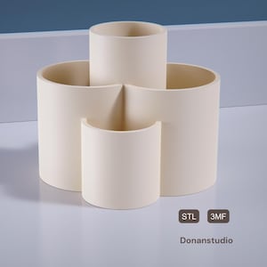May include: A white ceramic desk organizer with three compartments. The organizer is shaped like a clover leaf.