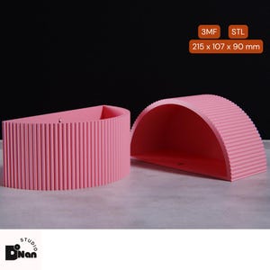 Pode incluir: Duas jardineiras de meia-lua cor de rosa com textura canelada. A jardineira maior mede 21,5 cm por 10,7 cm por 9 cm. A jardineira menor mede 10,7 cm por 9 cm. 3MF STL