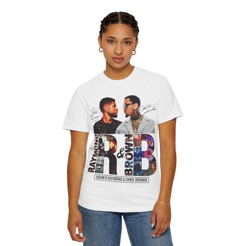 K&ouml;nnte beinhalten: Wei&szlig;es T-Shirt mit einer Grafik von Usher Raymond und Chris Brown. Das Design enth&auml;lt den Text "RAYMOND & BROWN" und die Namen der K&uuml;nstler. Das Shirt hat einen Rundhalsausschnitt und kurze &Auml;rmel.