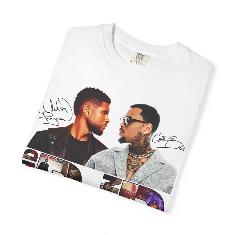 K&ouml;nnte beinhalten: Wei&szlig;es T-Shirt mit einer Grafik von zwei sich gegen&uuml;berstehenden M&auml;nnern, mit Unterschriften oben und unten. Das Bild enth&auml;lt den Text "Usher Here I Stand" und "Chris Brown". Das T-Shirt ist auf einer wei&szlig;en Oberfl&auml;che gefaltet.