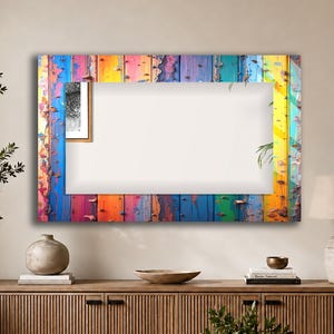 Pode incluir: Um espelho de parede retangular com uma moldura com design de tábuas de madeira multicoloridas e desgastadas. A moldura apresenta listras verticais em tons vibrantes de azul, amarelo, rosa, laranja e verde com textura de tinta descascada.