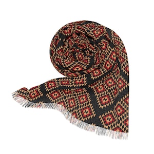 Könnte beinhalten: Gerollter schwarzer Schal mit einem geometrischen Muster in Rot und Beige. Der Schal hat einen Fransenrand. Das Muster ist ein sich wiederholendes Rautenmuster.
