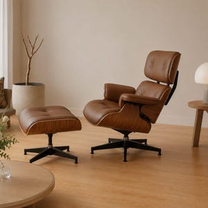 Peut inclure: Un fauteuil de salon et un ottoman de style moderne du milieu du siècle. Le fauteuil et l'ottoman sont en cuir marron avec une structure en bois et une base en métal noir. Le fauteuil a un dossier haut et des accoudoirs. L'ottoman est rectangulaire.