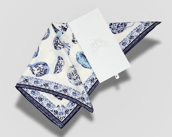 May include: A white silk scarf with a blue and white floral pattern. The pattern features stylized flowers and leaves in a traditional Chinese design.