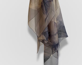 May include: A sheer scarf with a floral print in shades of brown and gray. The scarf is draped and folded, showing the intricate design.