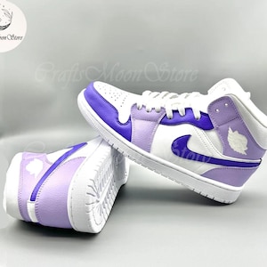 May include: White and purple high-top sneakers with a white sole. The sneakers feature a purple swoosh and accents, with a white and purple design on the heel. The shoes are branded with the text "Crafts Moon Store".