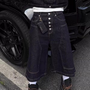 Denim Cropped Pants | Loose Wide Leg Workwear Jorts | Daily Wear | Avant Streetwear Style

Black raw denim cropped wide-leg pants with button front detail, styled in a bold streetwear outfit outdoors.