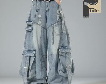 May include: Light blue denim cargo pants with a wide leg design. The pants feature multiple pockets, distressed details, and adjustable straps. The pants have a relaxed fit and a faded wash.