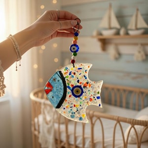 Pu&ograve; includere: Un ornamento a forma di pesce in vetro colorato con testa blu, labbra rosse e occhio blu. Il pesce &egrave; decorato con pezzi di vetro colorati e un cordino di perline per appenderlo. Articolo decorativo.