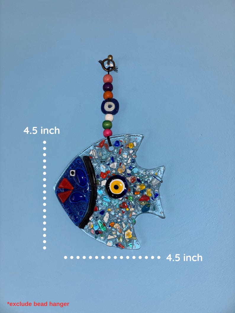 A decorative glass fish, 4.5 inches in length, with a blue body and mosaic-style design. The fish features a blue eye, red beak, and a yellow and black eye. It hangs from a beaded strand with colorful beads.