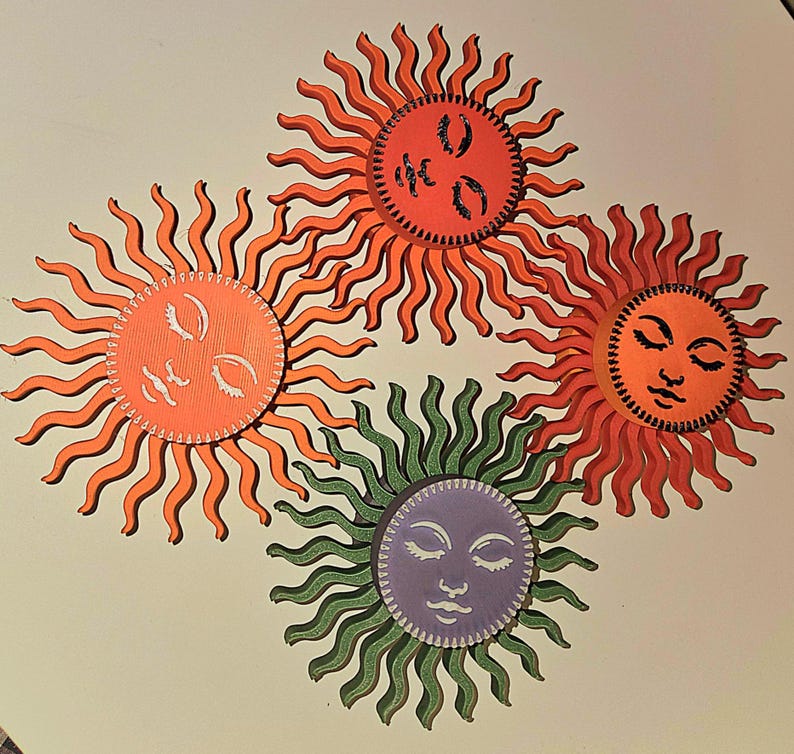 Puede incluir: Cuatro ilustraciones estilizadas de soles con ojos cerrados y varios colores. Los soles tienen caras naranjas, rojas, verdes y moradas con rayos ondulados. El fondo es de color beige claro.