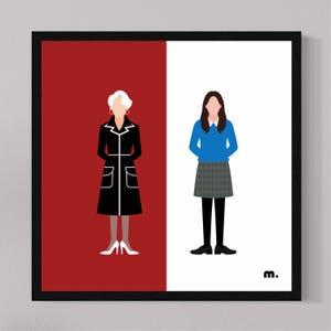 Peut inclure: Impression d'art encadrée avec deux personnages stylisés. L'un porte un manteau noir avec des détails blancs, l'autre un pull bleu et une jupe à carreaux. Le fond est divisé en rouge et blanc.