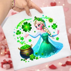 May include: White pillow with a St. Patrick's Day design featuring a cartoon princess in a green dress, surrounded by shamrocks and a pot of gold. The princess has blonde hair and is wearing a green shamrock crown.