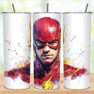 May include: A white tumbler with a colorful watercolor design of The Flash, a superhero with a red mask and lightning bolt symbol. The design is abstract and features splashes of color.