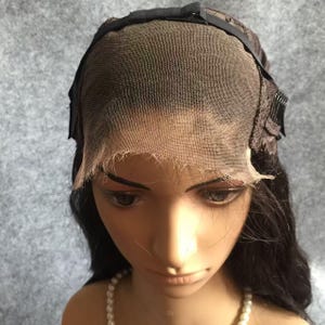 May include: A black lace front wig with adjustable straps and combs. The wig is made of human hair and has a natural, wavy texture.