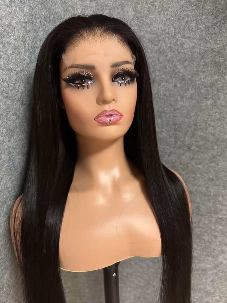 May include: A long, straight black wig with a lace front. The wig is on a mannequin head and has a natural, sleek look.