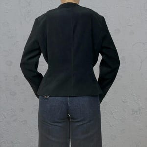 Peut inclure: Un blazer noir &agrave; manches longues et &agrave; taille cintr&eacute;e. Le blazer est fait d'un tissu lisse et textur&eacute;.
