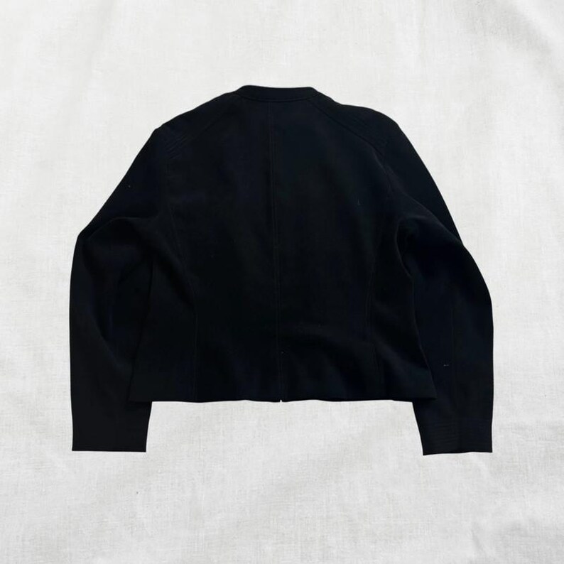 Peut inclure: Un blazer noir &agrave; manches longues et au design simple.
