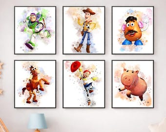 Op de afbeelding: Een set van zes vierkante wandkunstprints met aquarelillustraties van Toy Story-personages, waaronder Buzz Lightyear, Woody, Mr. Potato Head, Bullseye, Jessie en Hamm, elk tegen een achtergrond met zachte verfspatten.