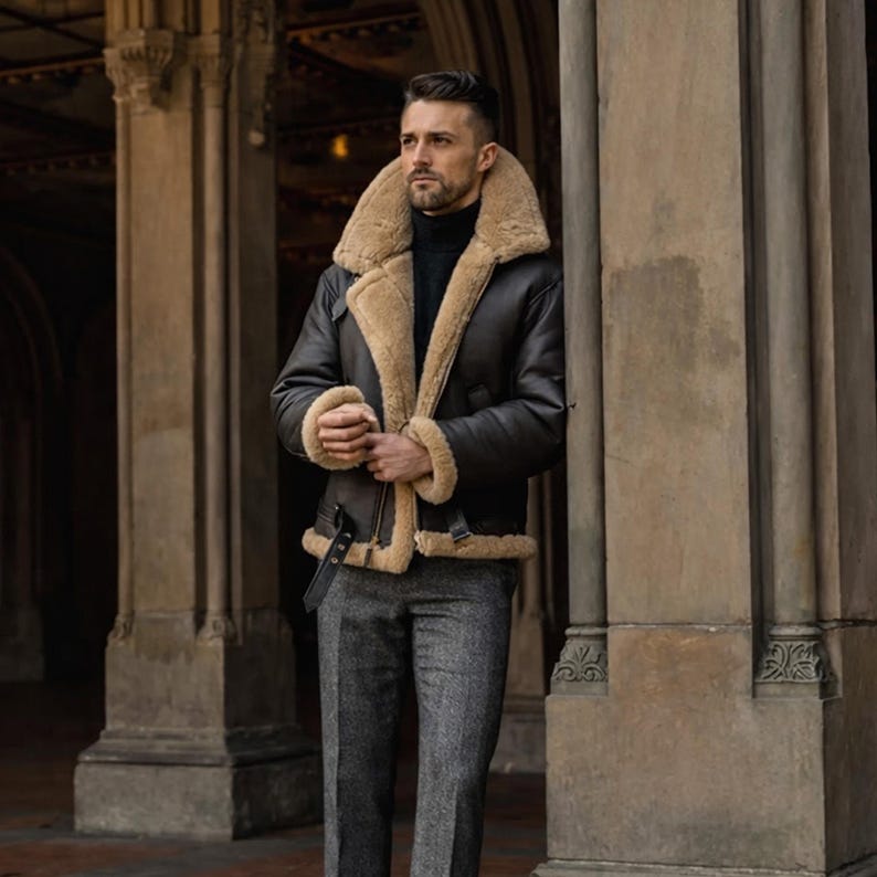 Pu&ograve; includere: Giacca in montone marrone scuro con fodera e colletto in montone beige. La giacca ha una cintura nera e viene indossata con pantaloni di tweed grigi. Le misure della giacca non sono visibili.