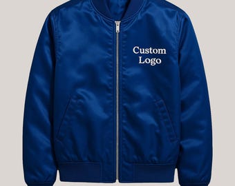 Könnte beinhalten: Königsblaue Bomberjacke mit Reißverschluss und gerippten Bündchen und Saum. Auf der Brust ist der Text "Custom Logo" in Weiß aufgedruckt. Die Jacke ist aus einem glänzenden, satinartigen Material gefertigt.