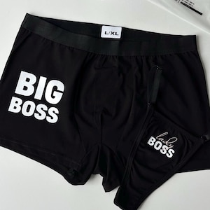 Może przedstawiać: Czarne bokserki z białym napisem "BIG BOSS". W zestawie pasujący czarny string z napisem "lady BOSS" w kolorze białym. Rozmiar L/XL.